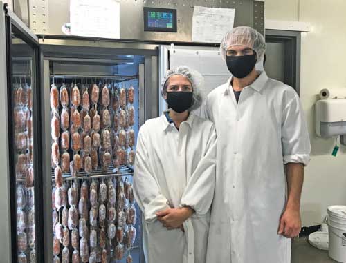 Agricola farm people standing in front of their freezer