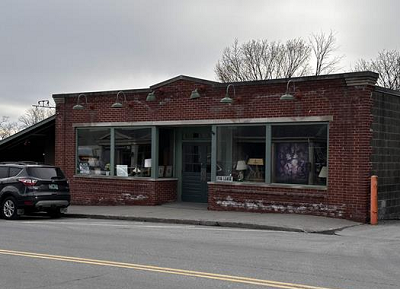 single story brick storefront on street with big windows. 